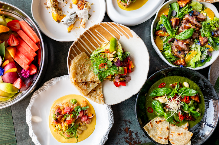 A vibrant display of gourmet dishes including fresh salads, grilled vegetables, and artisan bread