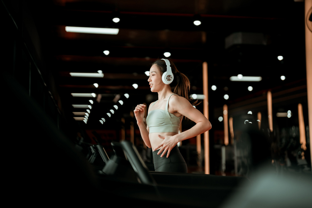 Young Asian Woman Running on Treadmill - Fitness Gym Exercise