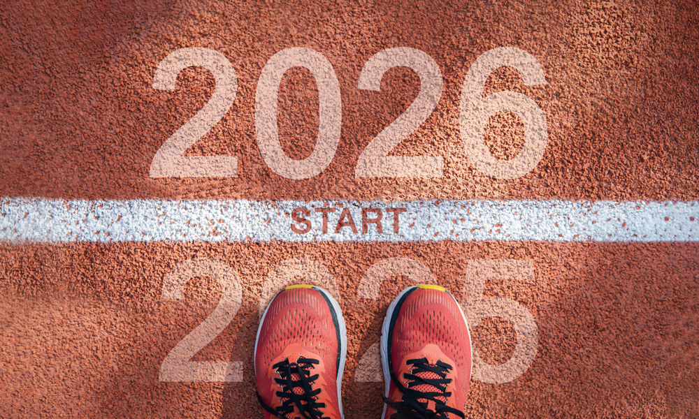 New year 2026 concept, beginning of success. Text 2026 written on asphalt road and male runner preparing for the new year. Concept of challenge or career path and change