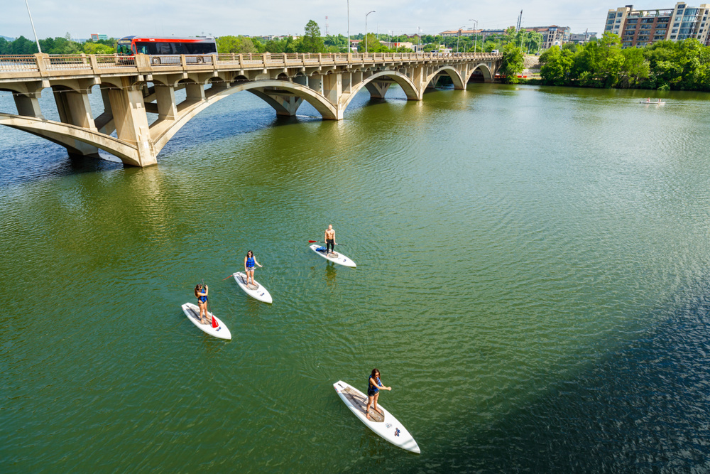 Paddle boarders cruising along the Colorado River by the Lamar Street Bridge in Downtown Austin