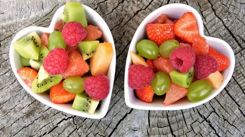 two heart-shaped bowls of different fruits