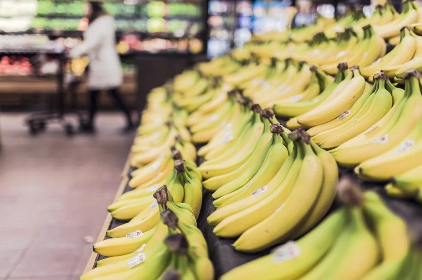 bananas piled up in a rack in a supermarket