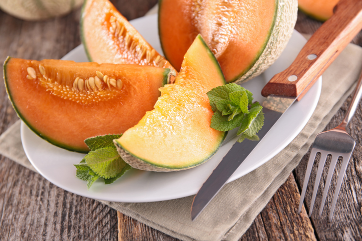 melon slices and mint on wood background