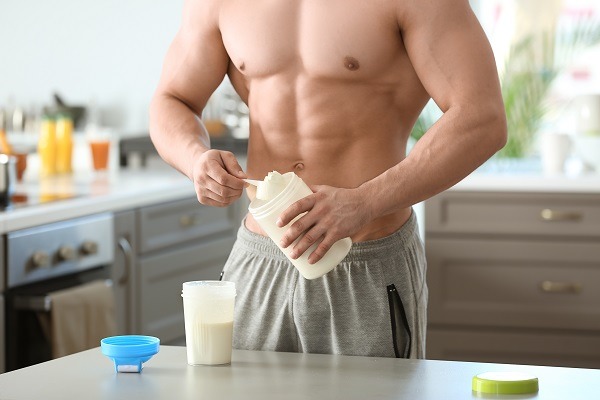 Sporty man making protein shake at home