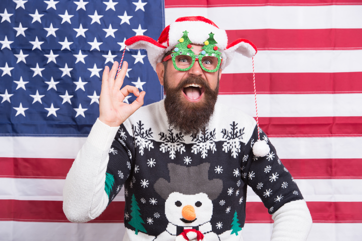 feeling ok. I like the party. Merry american xmas. Santa at american flag. Bearded american man celebrate new year. National us flag. Patriotic hipster celebrate winter holidays. Seasons greetings