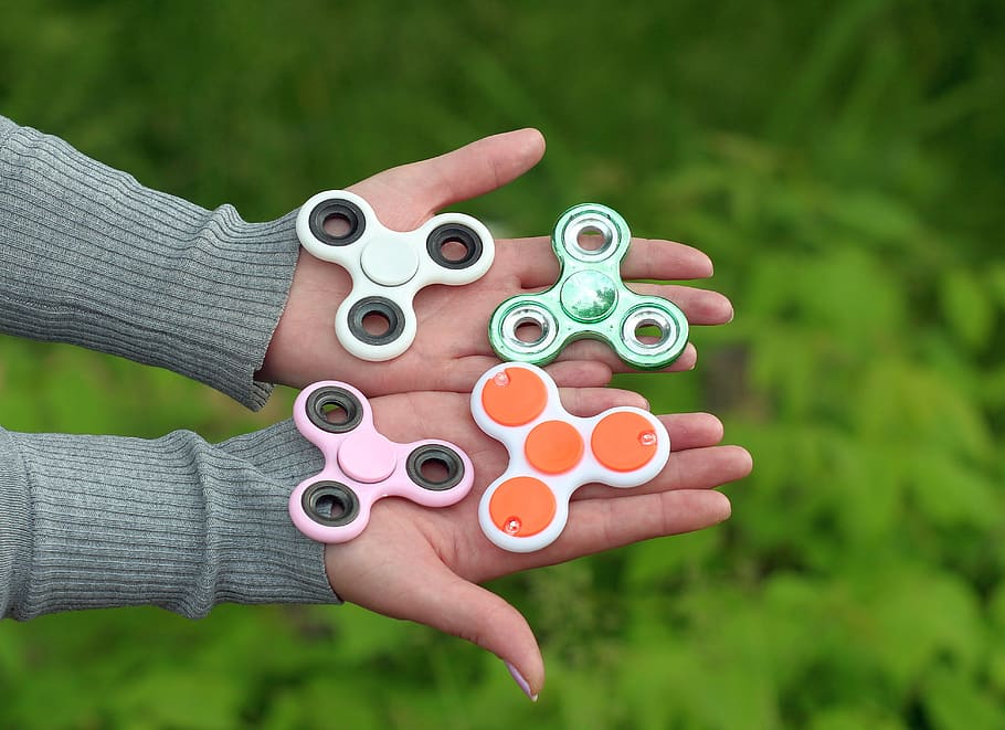 a child holding four fidget spinners