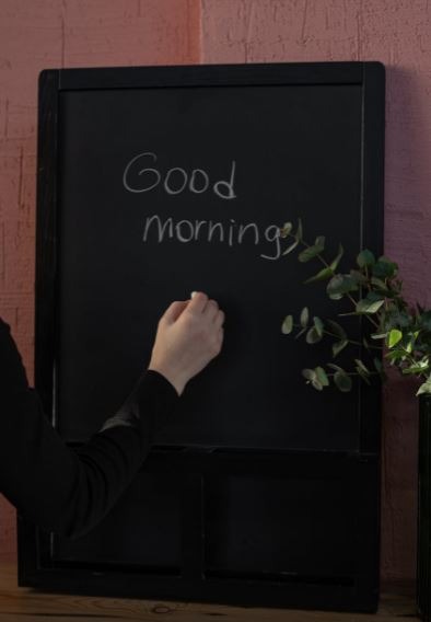 a-person-in-a-black-long-sleeve-shirt-writing-on-the-chalkboard