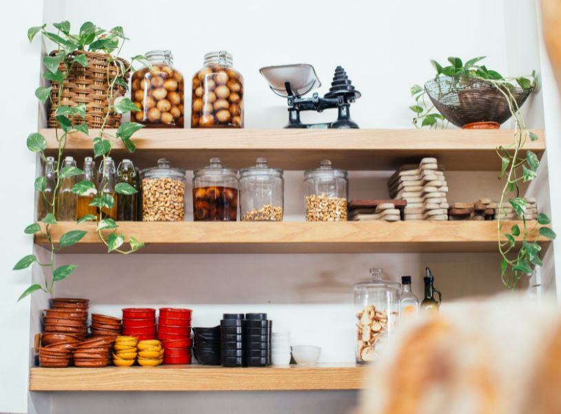 wooden-shelves-with-glass-jars-filled-with-various-ingredients-and-baskets-with-plants
